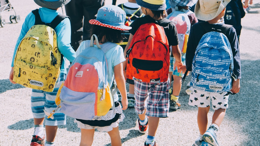 Kids with backpacks heading back to school in secondhand clothes