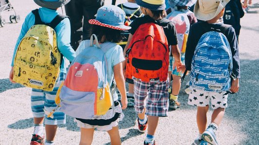 Kids with backpacks heading back to school in secondhand clothes
