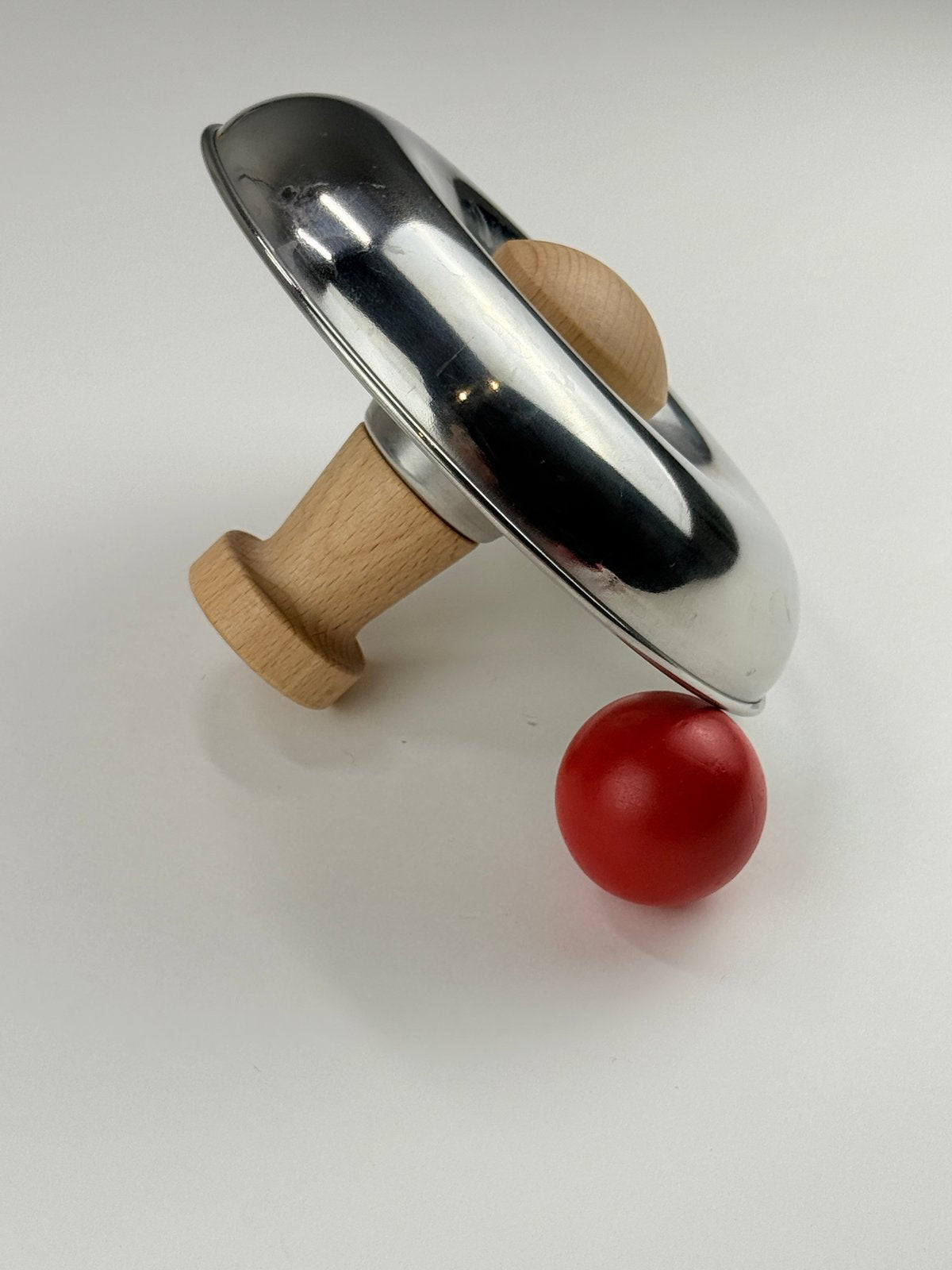 Lovevery Metal Spinning Bowl Toy with Red Ball